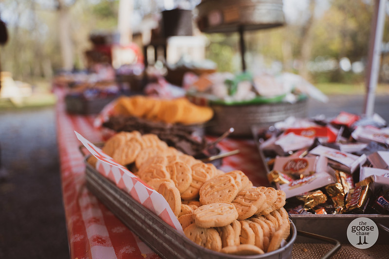S'mores bar with cookies and candy bars on a checkered tablecloth